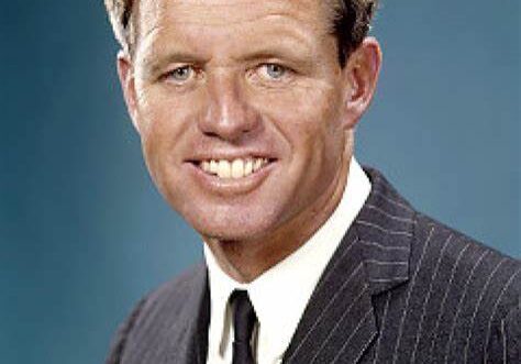 A man in a suit and tie smiling for the camera.